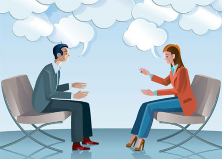 2 people sitting across from one another discussing something