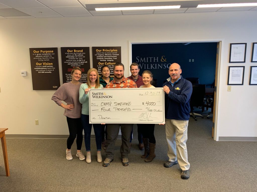 smith and wilkinson team holding large check